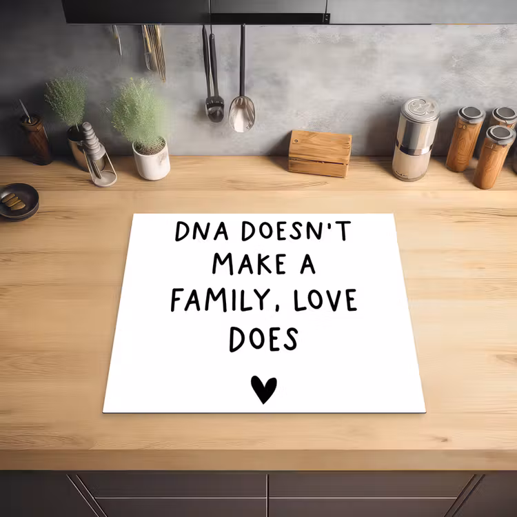 Engelse quote "DNA doesn't make a family, love does" met een hartje op een witte achtergrond Inductie beschermer vinyl 3mm middel -sfeer5