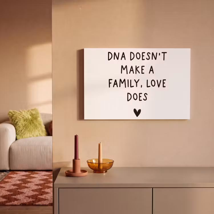 Engelse quote "DNA doesn't make a family, love does" met een hartje op een witte achtergrond canvas 2cm klein -sfeer1