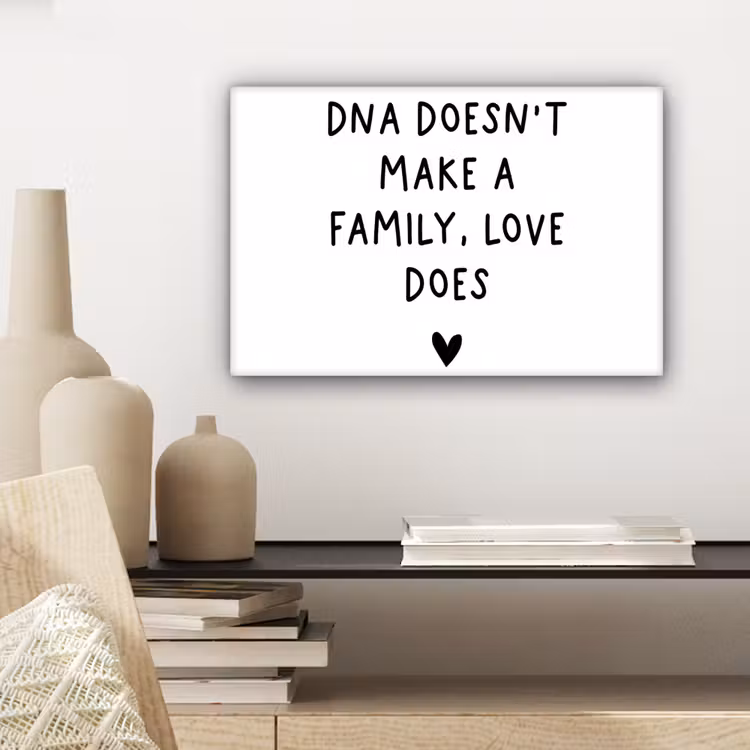 Engelse quote "DNA doesn't make a family, love does" met een hartje op een witte achtergrond canvas 2cm klein -sfeer6